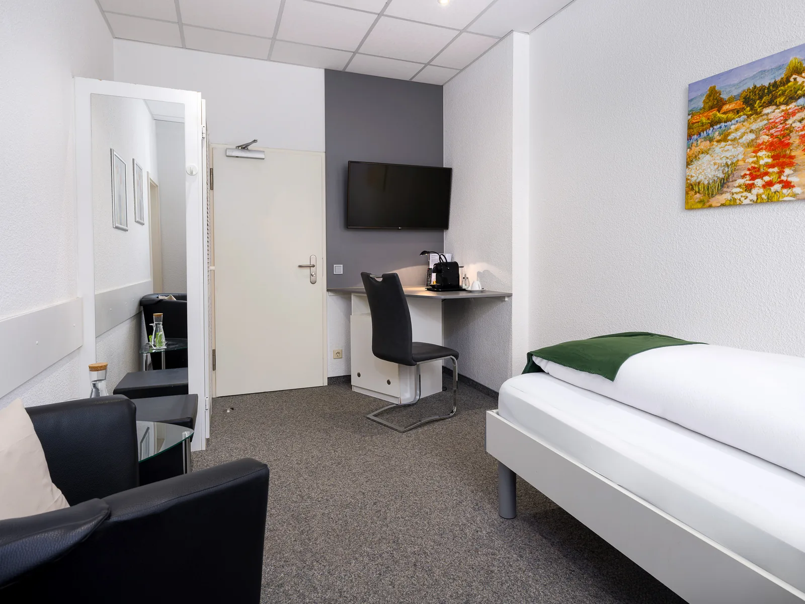 Einzelzimmer mit Bett, TV und Kaffeemaschine im Hotel Jägerhof Herne