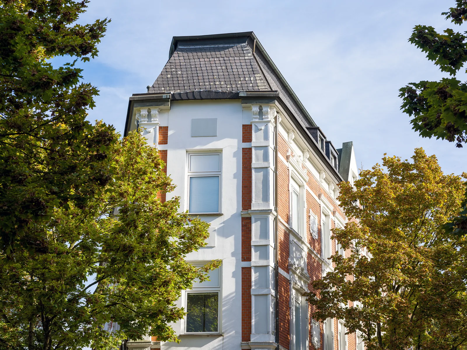 Historische Fassade des Hotel Jägerhof Herne zwischen grünen Bäumen